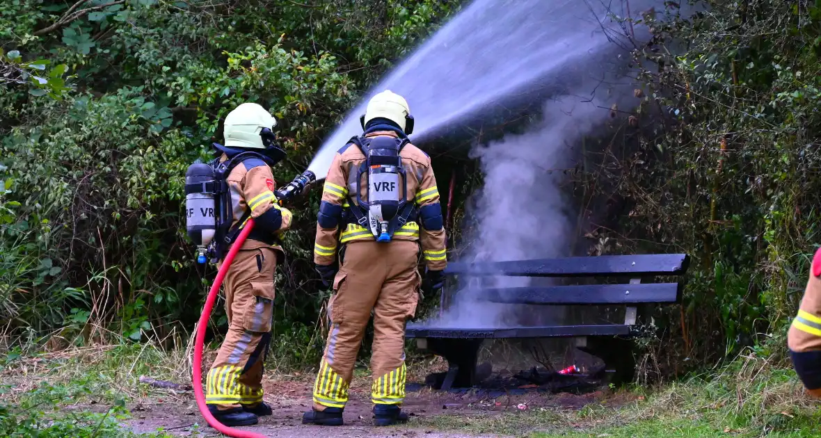 Brandweer blust brandende houten bank