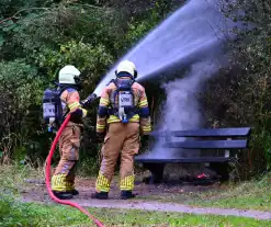 Brandweer blust brandende houten bank