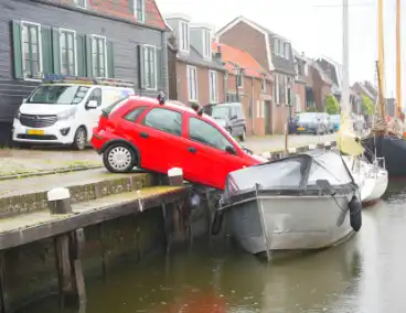 Auto rolt tegen boot aan