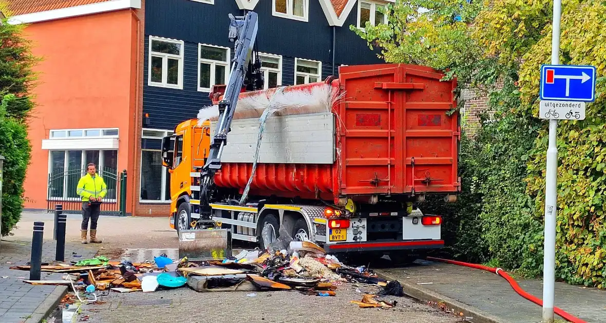 Containerwagen dumpt brandend afval op straat