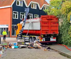 Containerwagen dumpt brandend afval op straat