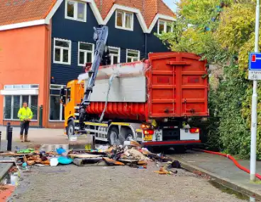 Containerwagen dumpt brandend afval op straat