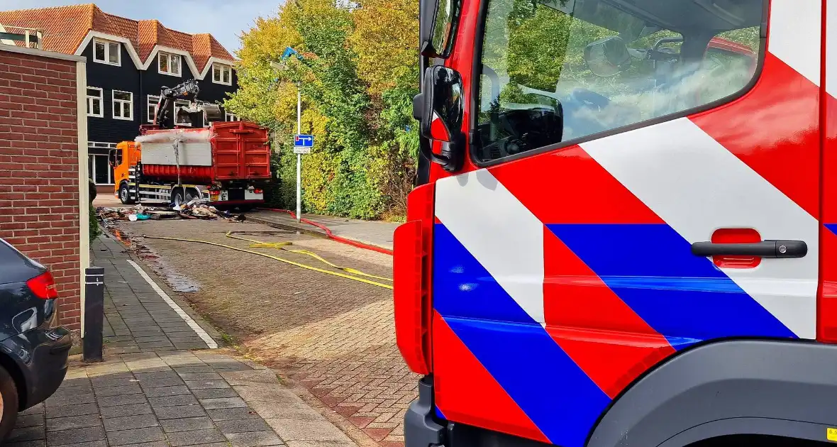 Containerwagen dumpt brandend afval op straat - Foto 2