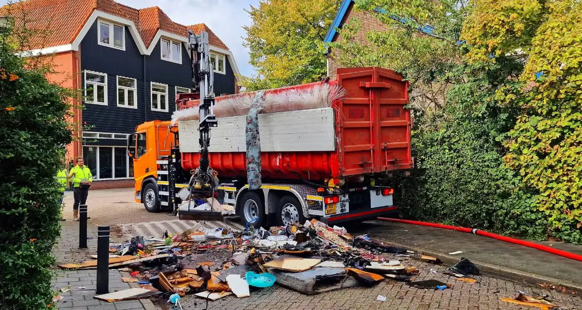 Containerwagen dumpt brandend afval op straat - Foto 3