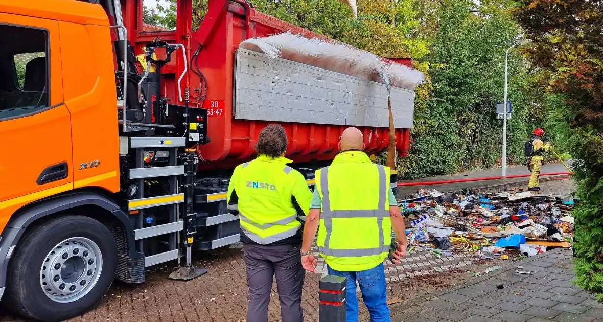 Containerwagen dumpt brandend afval op straat - Foto 4