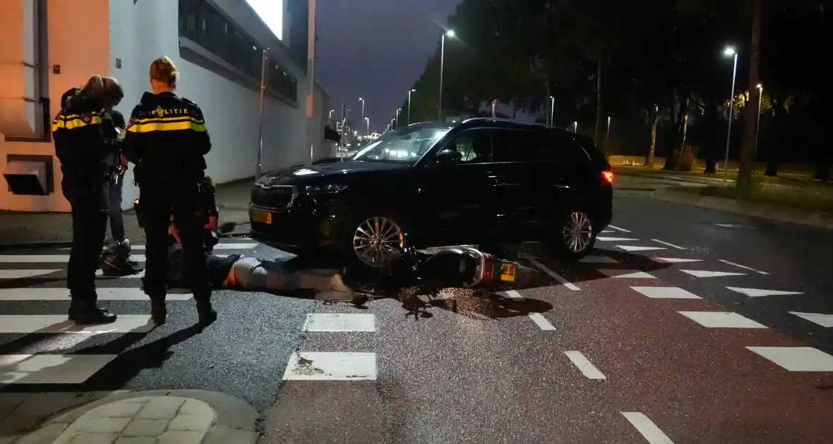 Scooterrijder klapt op personenauto - Foto 1