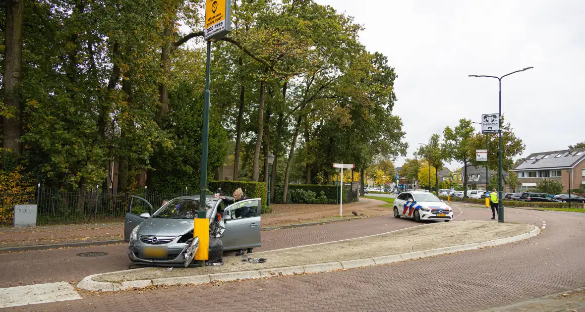 Automobilist ramt verkeersbord en lantaarnpaal