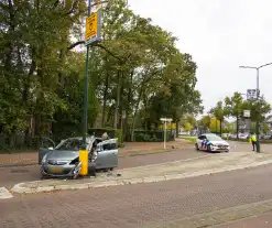 Automobilist ramt verkeersbord en lantaarnpaal