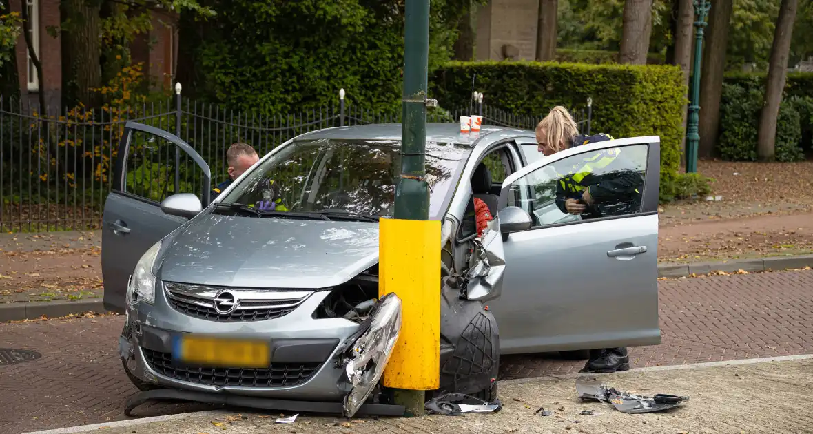 Automobilist ramt verkeersbord en lantaarnpaal - Foto 1