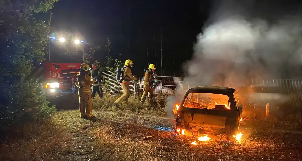 Brandweer blust brandende auto in bosgebied - Foto 2