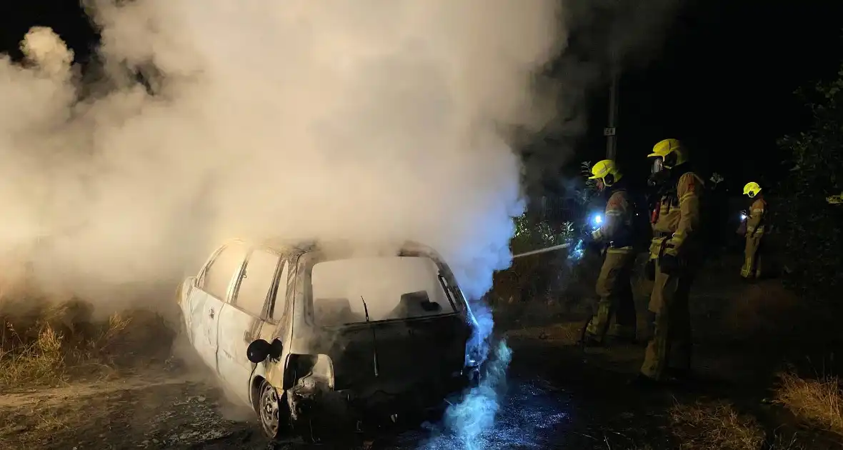 Brandweer blust brandende auto in bosgebied - Foto 5