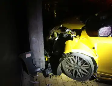 Auto crasht tegen gebouw, inzittenden ongedeerd