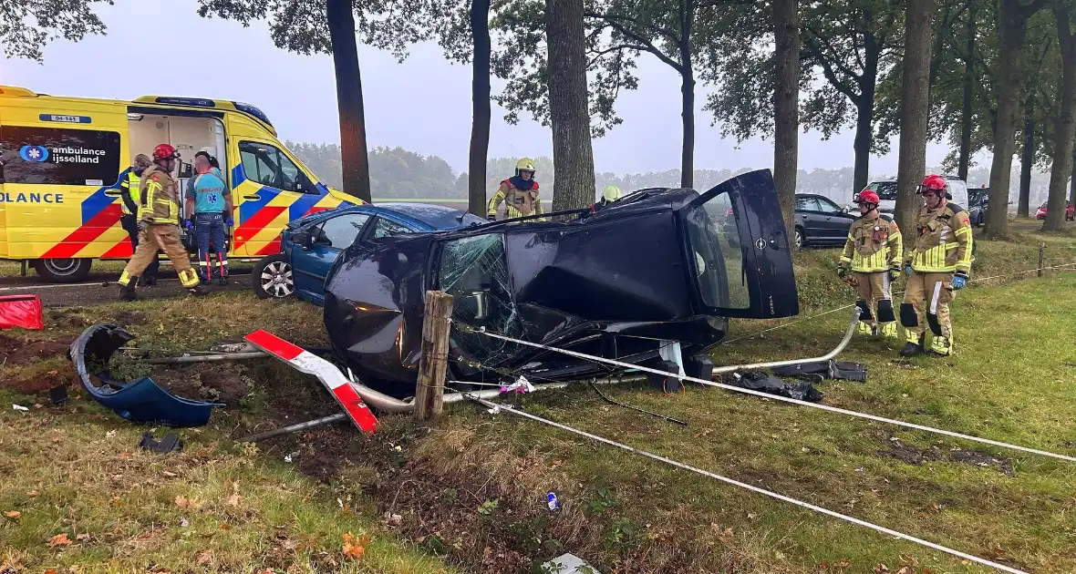 Gewonde en ravage na botsing, auto belandt op zijkant - Foto 4