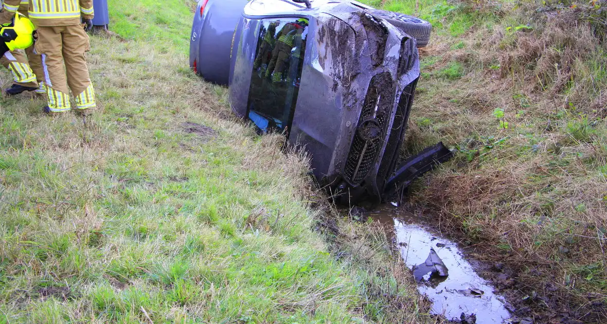 Personenauto belandt op de zijkant in sloot - Foto 1