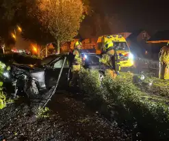 Personenauto ramt geparkeerde auto en belandt in voortuin