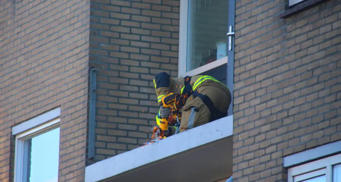 Persoon door hijskraan uit flatwoning getakeld - Foto 1