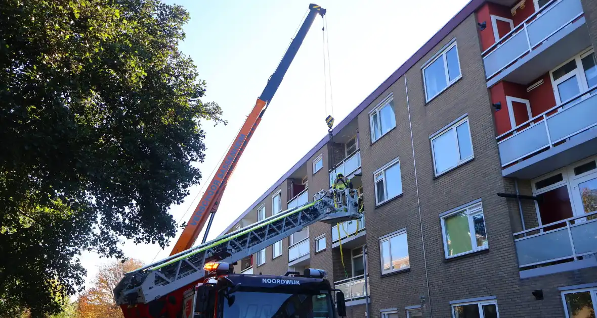 Persoon door hijskraan uit flatwoning getakeld - Foto 15