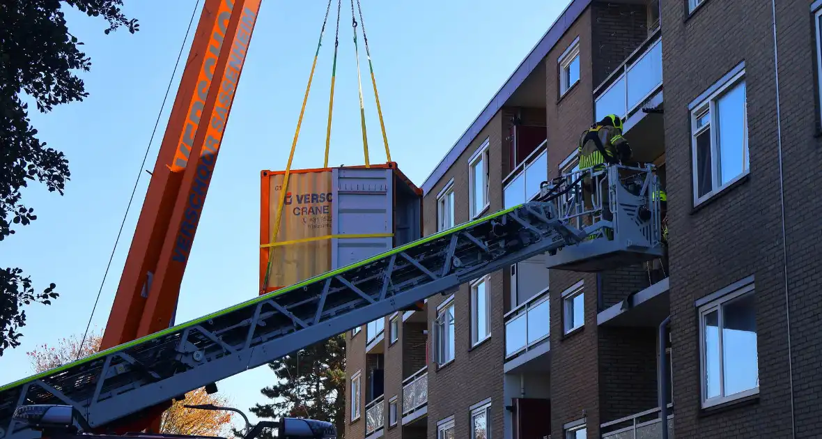 Persoon door hijskraan uit flatwoning getakeld - Foto 16