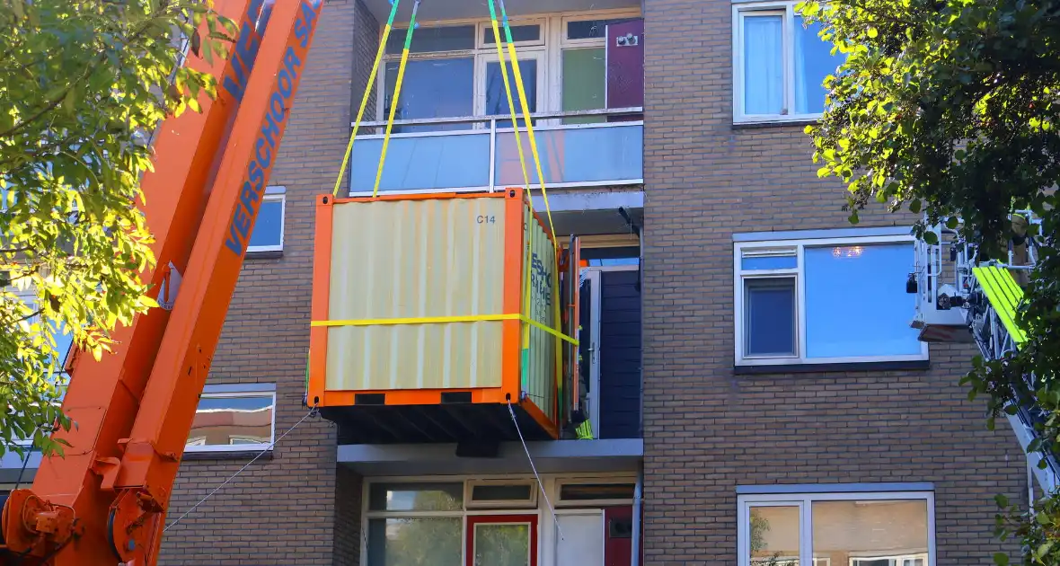 Persoon door hijskraan uit flatwoning getakeld - Foto 17