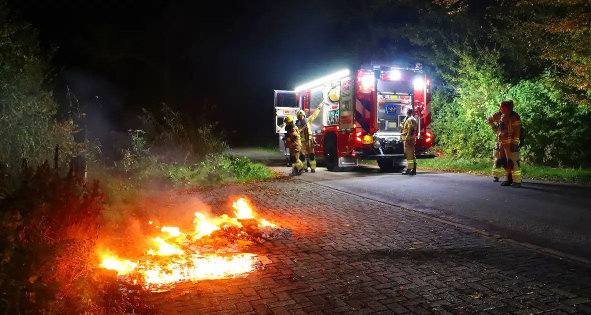 Brandweer dooft in brand gestoken afval