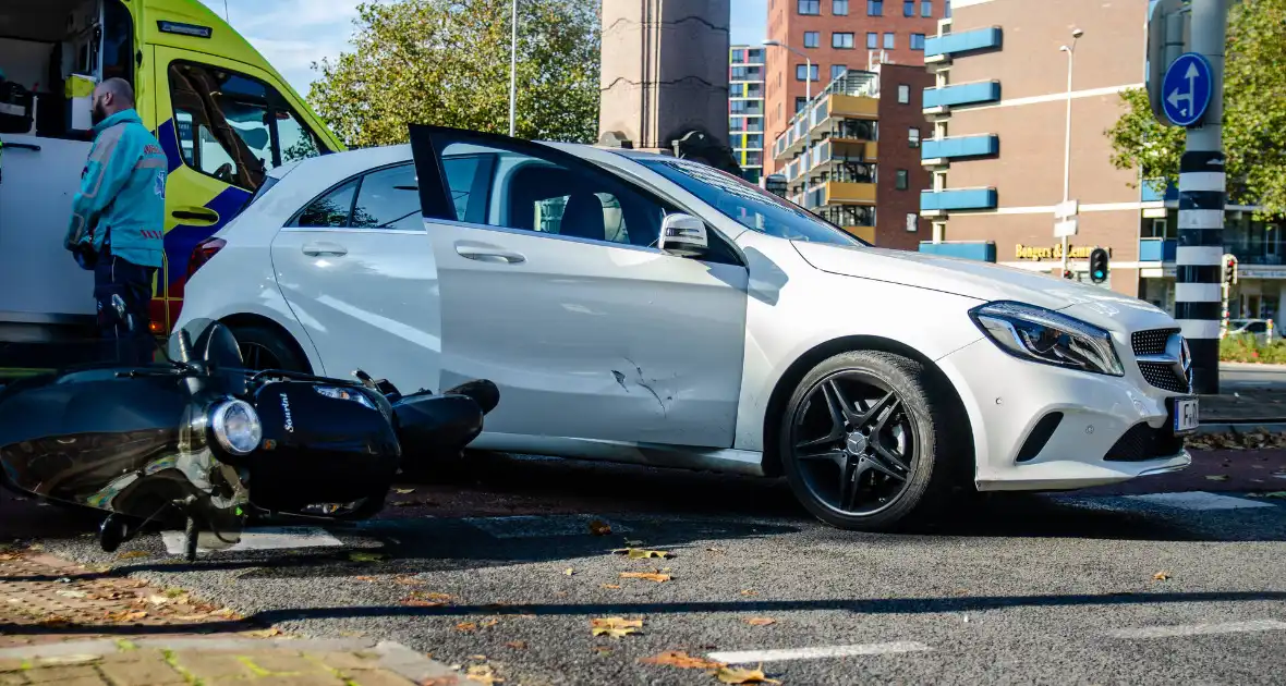 Scooter rijdt in zijkant van auto - Foto 1