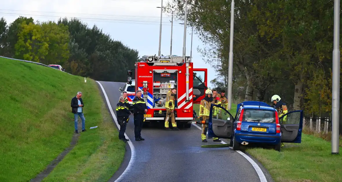 Personenauto vat vlam onder motorkap