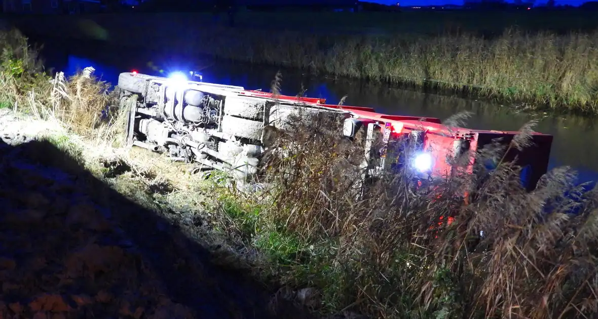 Vrachtwagen op zijn kant in de sloot