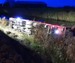 Vrachtwagen op zijn kant in de sloot