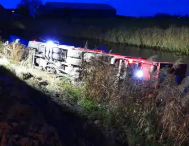 Vrachtwagen op zijn kant in de sloot