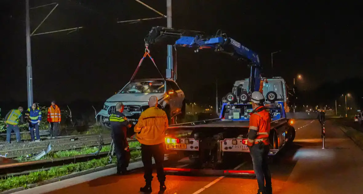 Auto vliegt over vangrail en crasht op trambaan - Foto 1