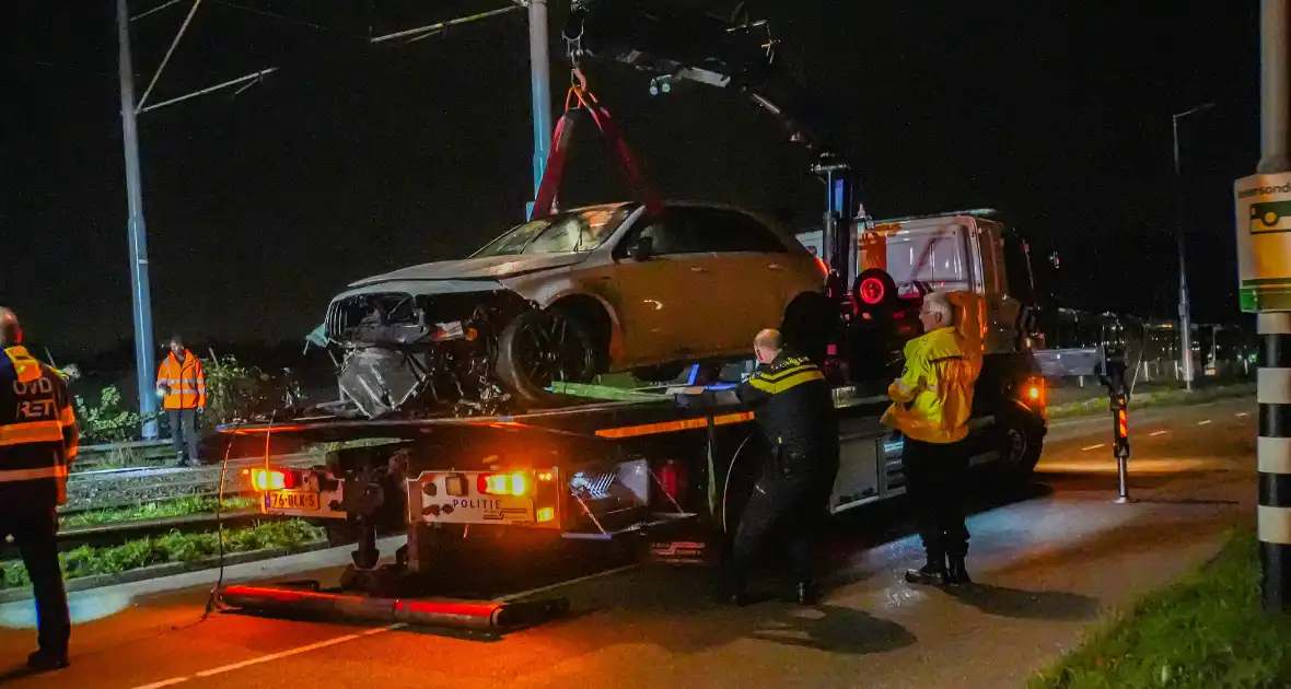 Auto vliegt over vangrail en crasht op trambaan - Foto 3