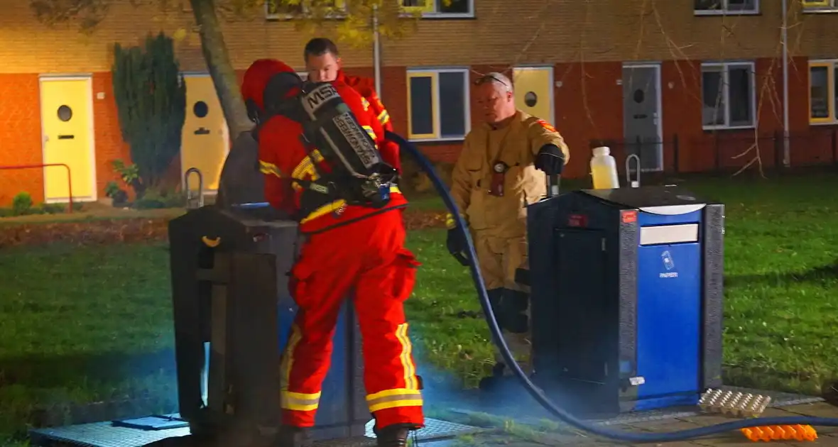 Brandweer blust brand in ondergrondse papiercontainer