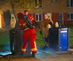 Brandweer blust brand in ondergrondse papiercontainer