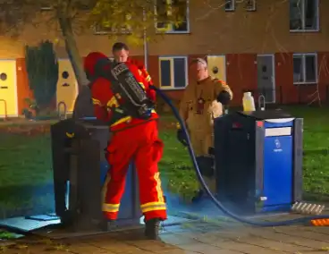 Brandweer blust brand in ondergrondse papiercontainer