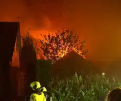 Vlammen slaan uit dak van schuur