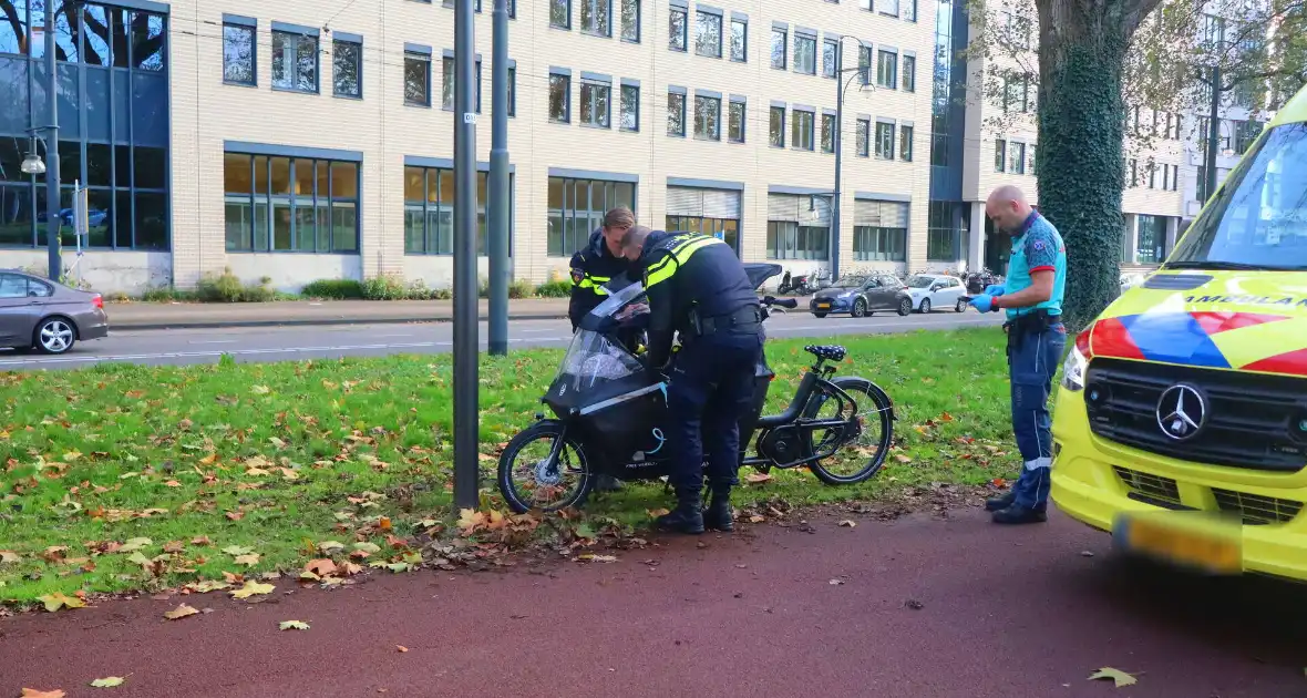 Persoon op bakfiets glijdt onderuit door bladeren op fietspad