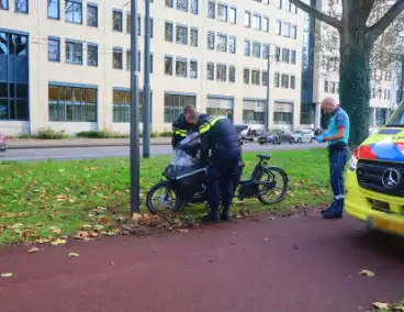 Persoon op bakfiets glijdt onderuit door bladeren op fietspad