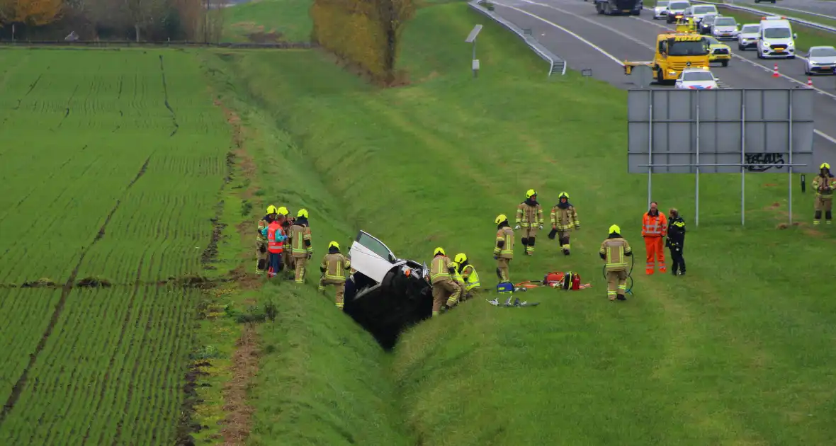 Automobiliste uit auto gehaald na crash vanaf snelweg - Foto 1