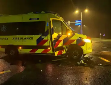 Auto botst met ambulance op kruising en belandt onderaan talud, inzittenden gewond