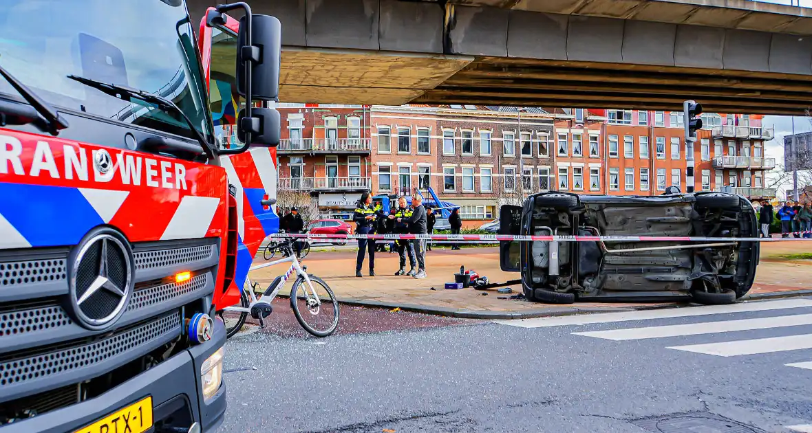 Twee voertuigen met elkaar in botsing een belandt op zijkant - Foto 1