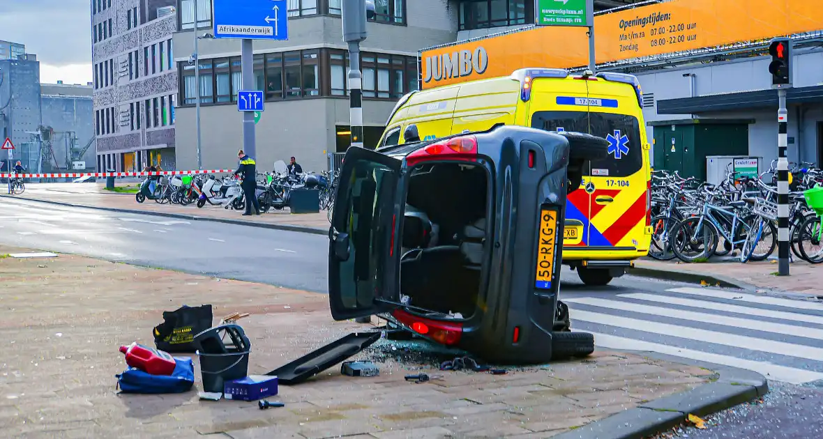 Twee voertuigen met elkaar in botsing een belandt op zijkant - Foto 3