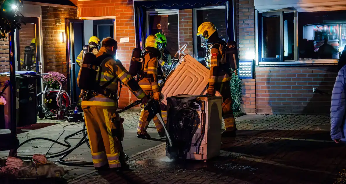 Brandweer blust brandende wasmachine