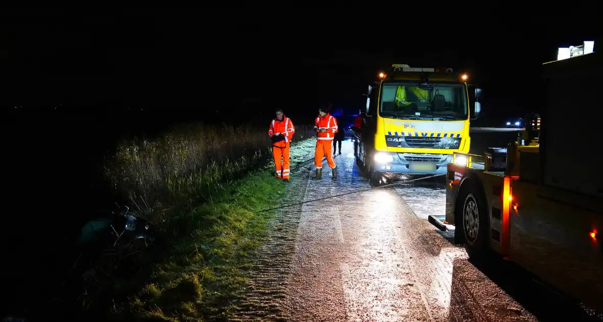 Twee auto's te water in bocht op gladde dijk - Foto 1