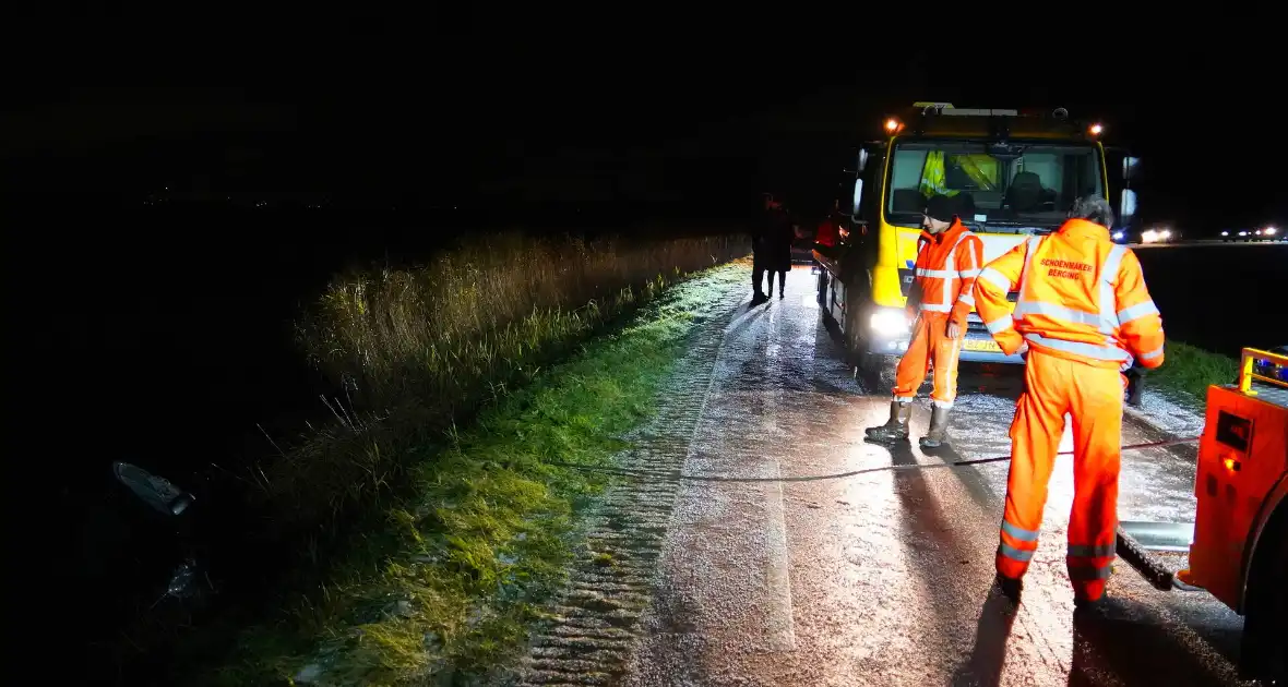 Twee auto's te water in bocht op gladde dijk - Foto 2