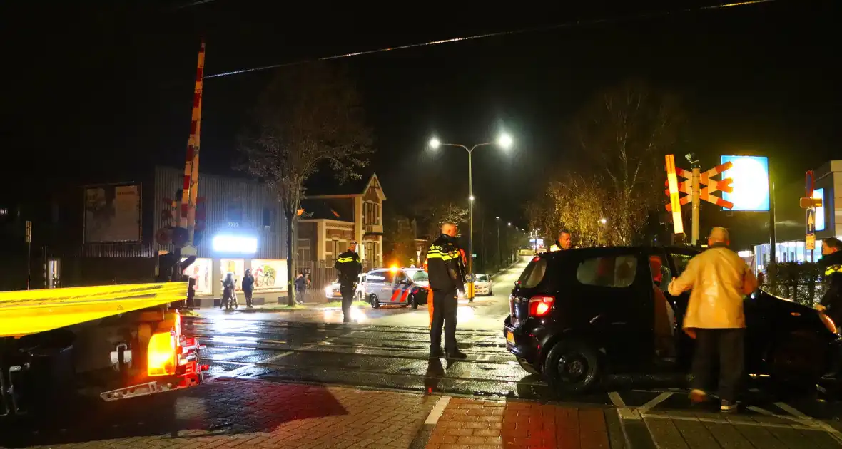 Auto belandt gedeeltelijk op spoor bij overweg