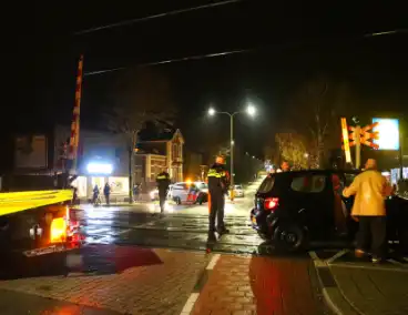 Auto belandt gedeeltelijk op spoor bij overweg