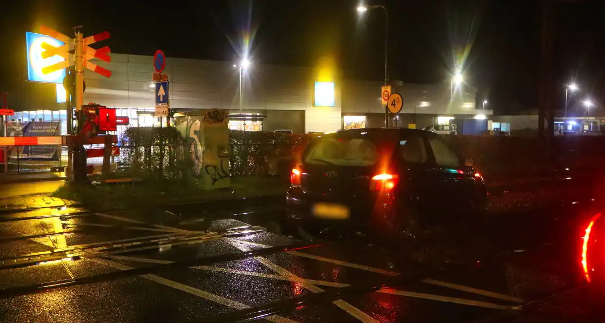 Auto belandt gedeeltelijk op spoor bij overweg - Foto 1