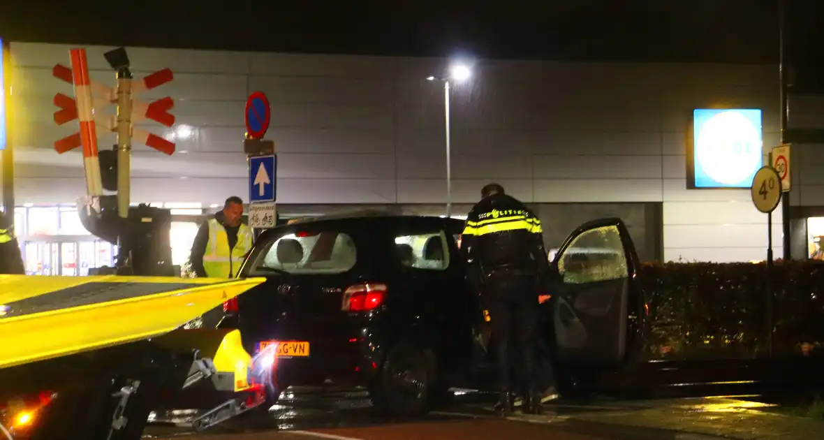 Auto belandt gedeeltelijk op spoor bij overweg - Foto 9