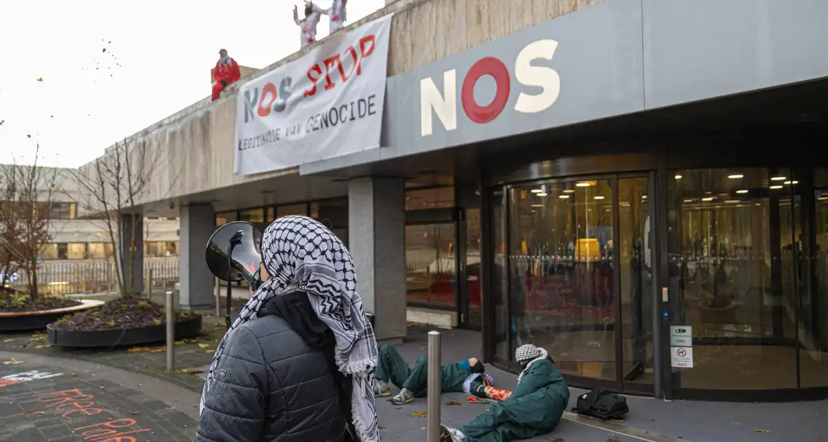 Demonstranten klimmen op het dak van NOS-gebouw - Foto 10