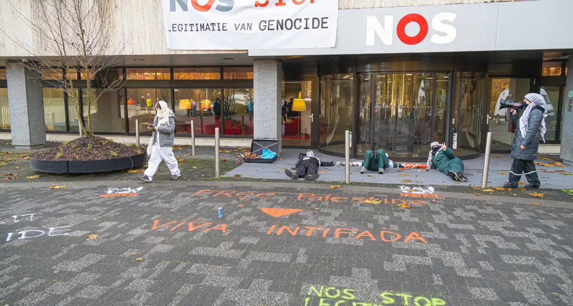 Demonstranten klimmen op het dak van NOS-gebouw - Foto 11